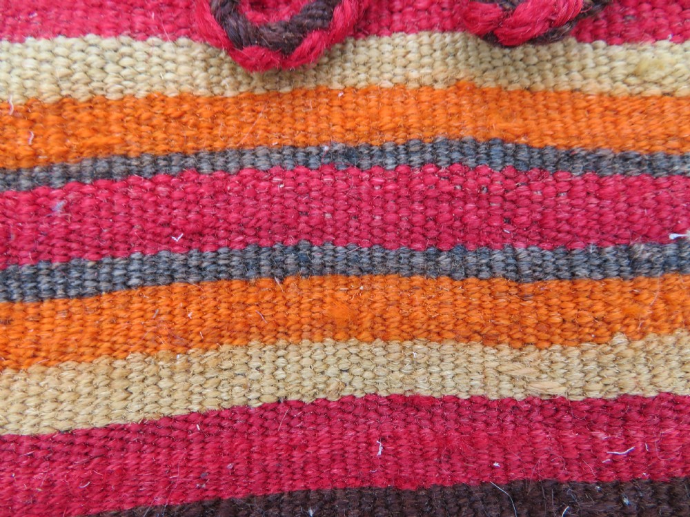 An antique woven wool Azerbaijan saddle bag displaying geometric serrated motifs in red, cream, and dark brown. View X