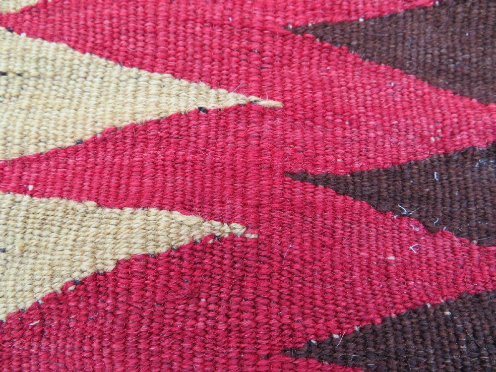 An antique woven wool Azerbaijan saddle bag displaying geometric serrated motifs in red, cream, and dark brown. View XI