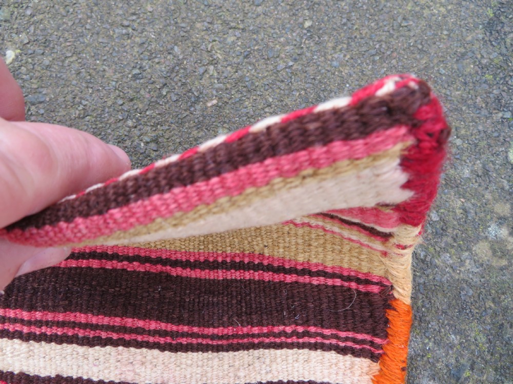 An antique woven wool Azerbaijan saddle bag displaying geometric serrated motifs in red, cream, and dark brown. View XX