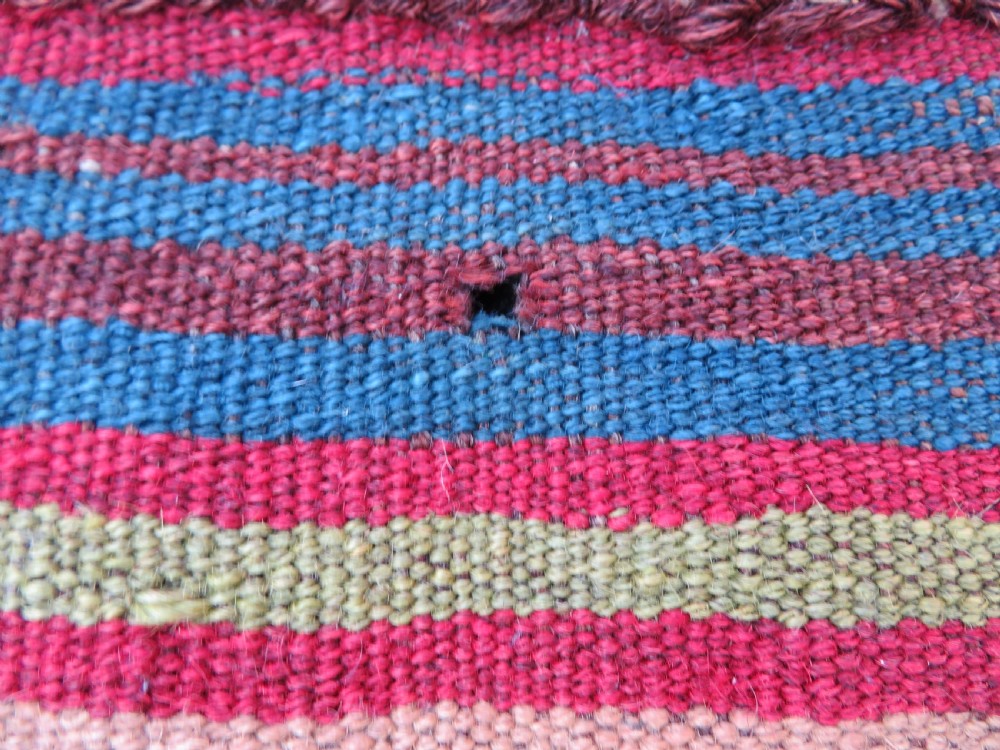 An antique flatweave rug featuring a central undyed tan wool field flanked by colourful horizontal striped end bands and braided fringe edges. View VI