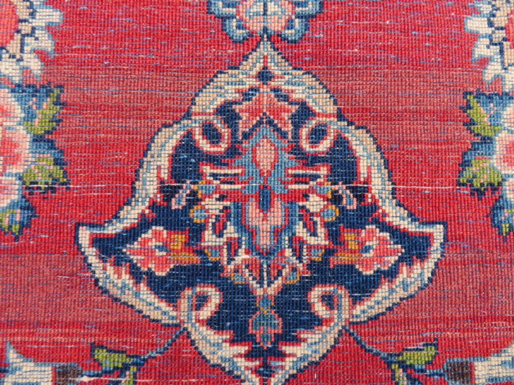 A hand-knotted Persian Kashan wool rug featuring a central navy and cream floral medallion on a rose pink field surrounded by floral spandrels and a navy border. View XXIII