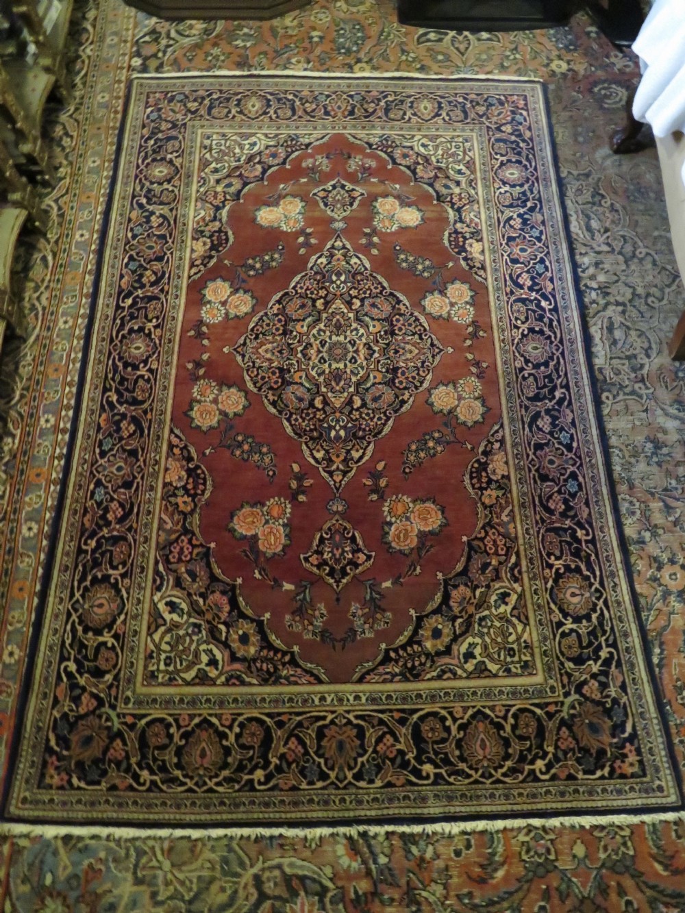 A hand-knotted Persian Kashan wool rug featuring a central navy and cream floral medallion on a rose pink field surrounded by floral spandrels and a navy border. View XXV