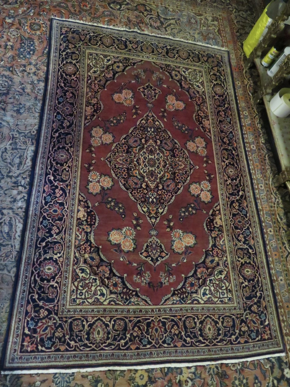 A hand-knotted Persian Kashan wool rug featuring a central navy and cream floral medallion on a rose pink field surrounded by floral spandrels and a navy border. View XXVI