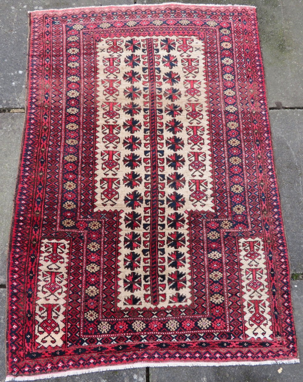 An antique hand-knotted Baluch wool rug featuring a central tree of life design on a cream field surrounded by red and navy geometric borders. View II