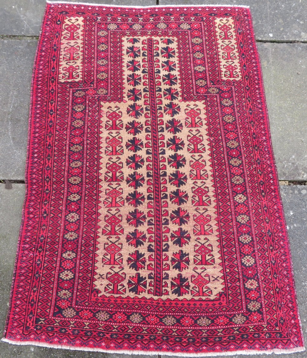 An antique hand-knotted Baluch wool rug featuring a central tree of life design on a cream field surrounded by red and navy geometric borders. View XIX