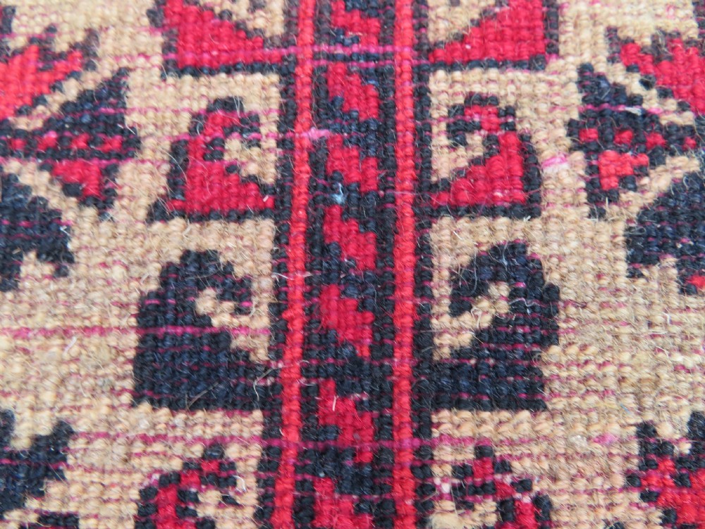 An antique hand-knotted Baluch wool rug featuring a central tree of life design on a cream field surrounded by red and navy geometric borders. View XXI