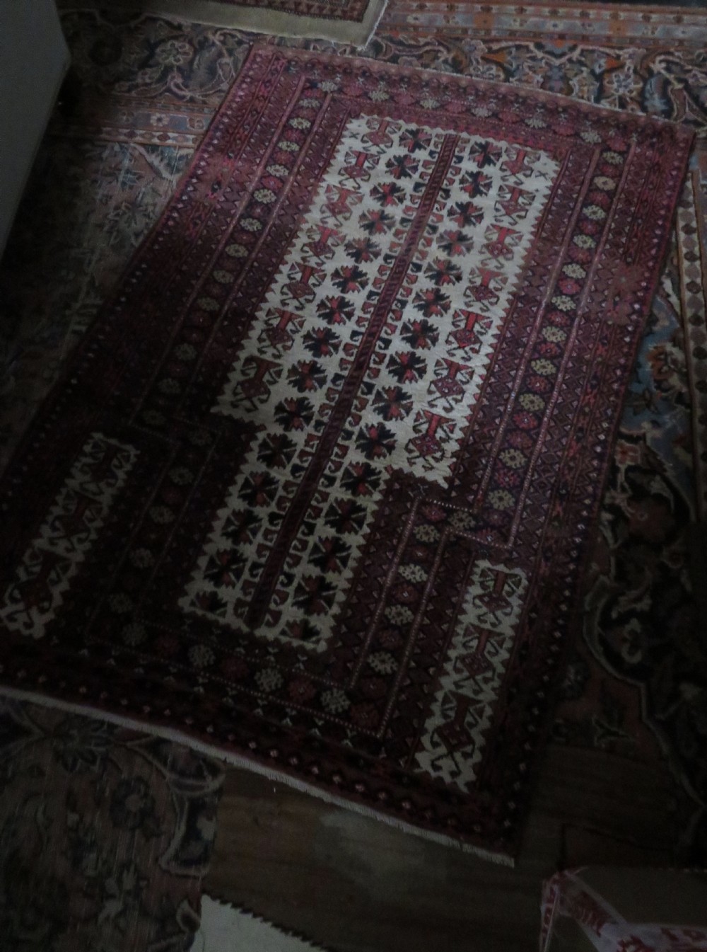 An antique hand-knotted Baluch wool rug featuring a central tree of life design on a cream field surrounded by red and navy geometric borders. View XXIII
