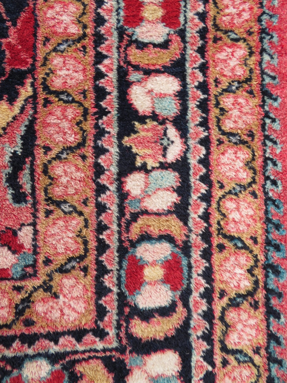 An antique Jozan Persian rug featuring a central floral medallion on a rose red field surrounded by intricate spandrels and multi-band patterned borders. View XIV