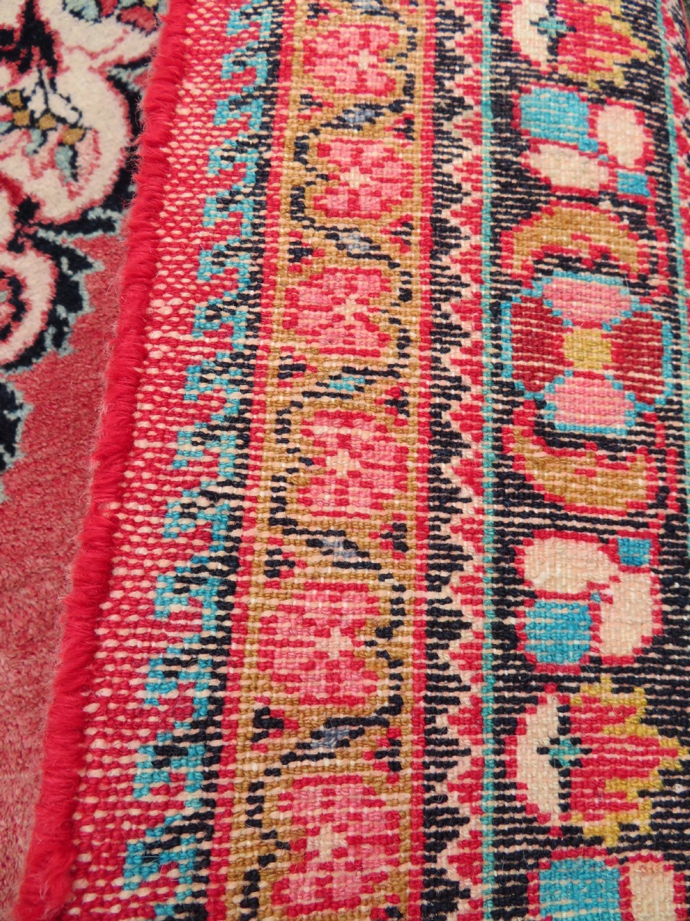An antique Jozan Persian rug featuring a central floral medallion on a rose red field surrounded by intricate spandrels and multi-band patterned borders. View XV
