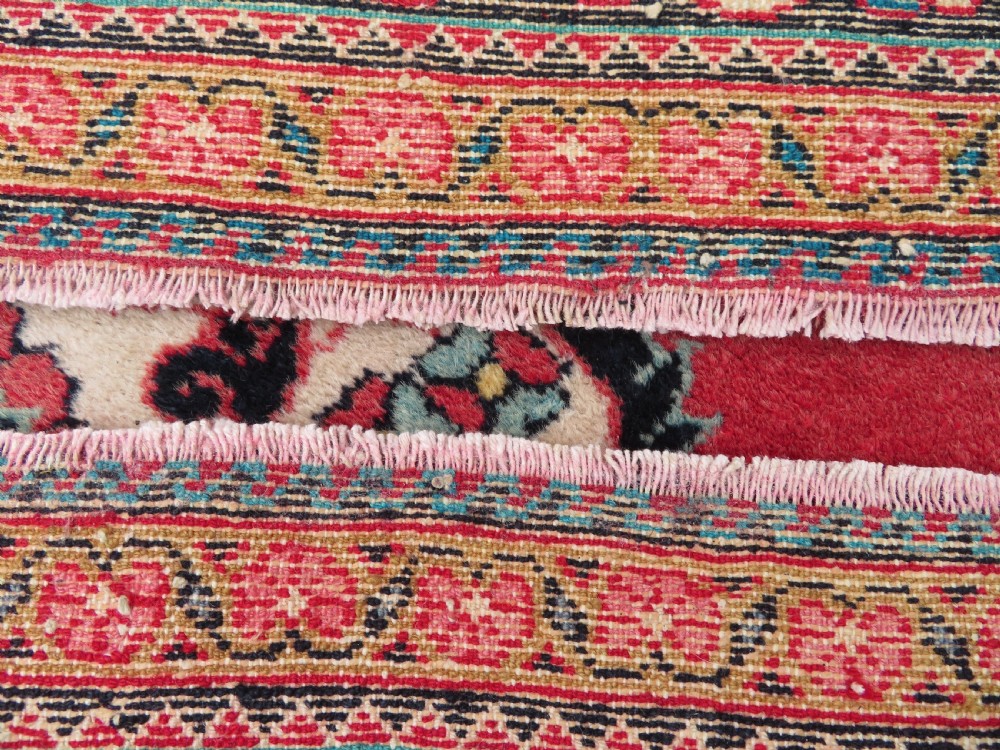 An antique Jozan Persian rug featuring a central floral medallion on a rose red field surrounded by intricate spandrels and multi-band patterned borders. View XVII
