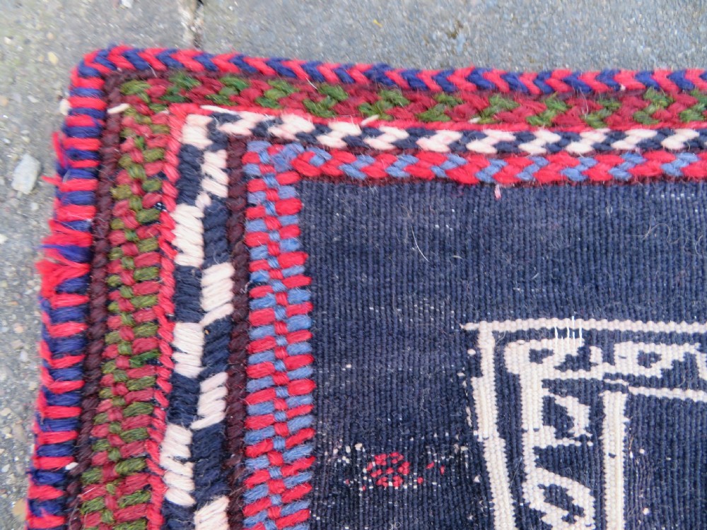 Square flatwoven antique Afshar sofreh rug featuring a central pink diamond medallion framed by nested red and navy blue stepped geometric borders. View VIII
