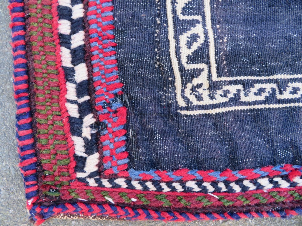 Square flatwoven antique Afshar sofreh rug featuring a central pink diamond medallion framed by nested red and navy blue stepped geometric borders. View IX