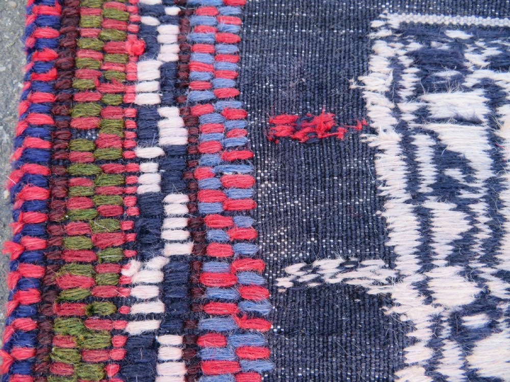 Square flatwoven antique Afshar sofreh rug featuring a central pink diamond medallion framed by nested red and navy blue stepped geometric borders. View XXI