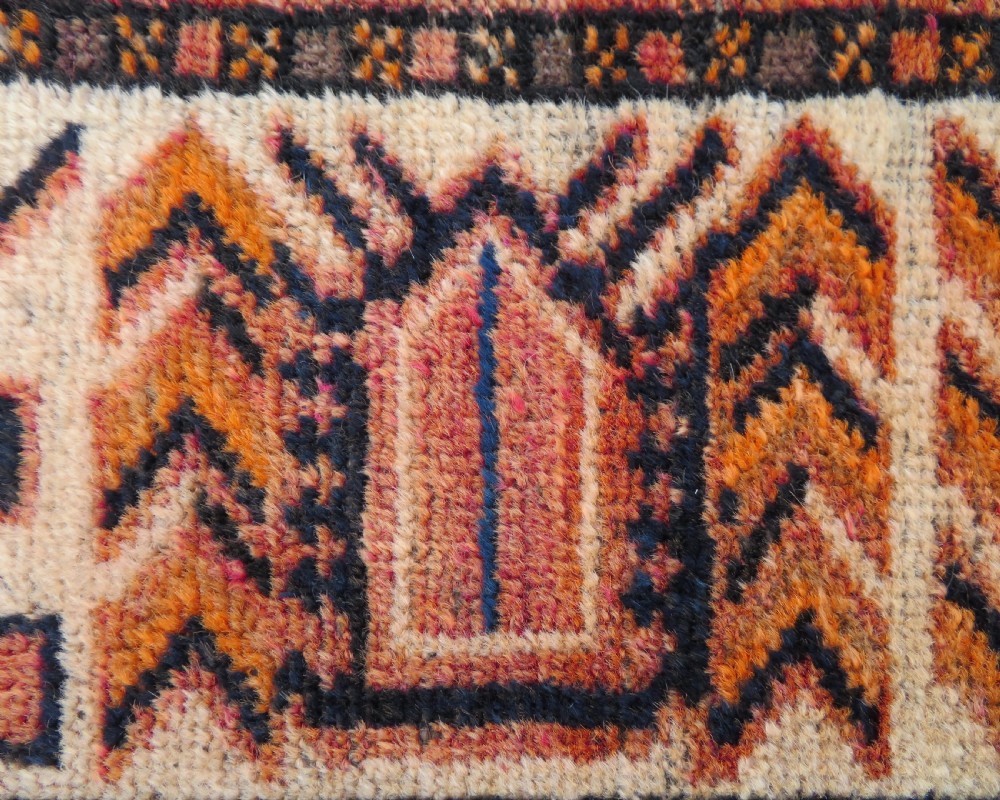 An antique hand-knotted Turkish Kurdish wool rug featuring a central terracotta diamond medallion surrounded by geometric motifs in dark indigo, cream, and orange shades. View VIII