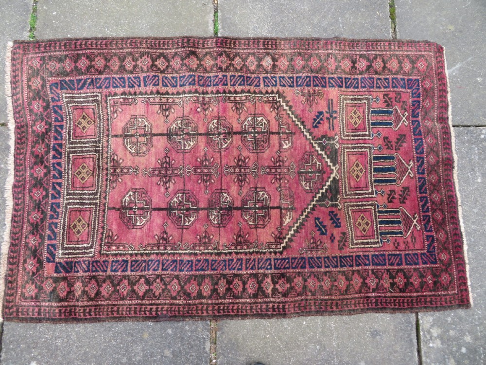 An antique hand-knotted Turkmen Kizil Ayak wool prayer rug featuring a triple mihrab arch design in deep red, dark blue, and charcoal shades. View III