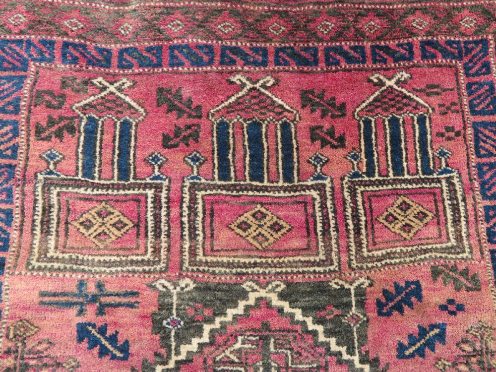 An antique hand-knotted Turkmen Kizil Ayak wool prayer rug featuring a triple mihrab arch design in deep red, dark blue, and charcoal shades. View V