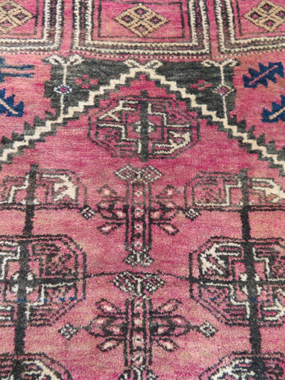 An antique hand-knotted Turkmen Kizil Ayak wool prayer rug featuring a triple mihrab arch design in deep red, dark blue, and charcoal shades. View VI