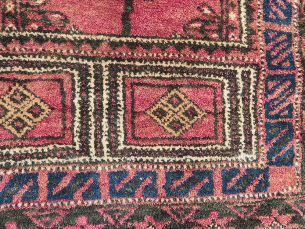 An antique hand-knotted Turkmen Kizil Ayak wool prayer rug featuring a triple mihrab arch design in deep red, dark blue, and charcoal shades. View VII