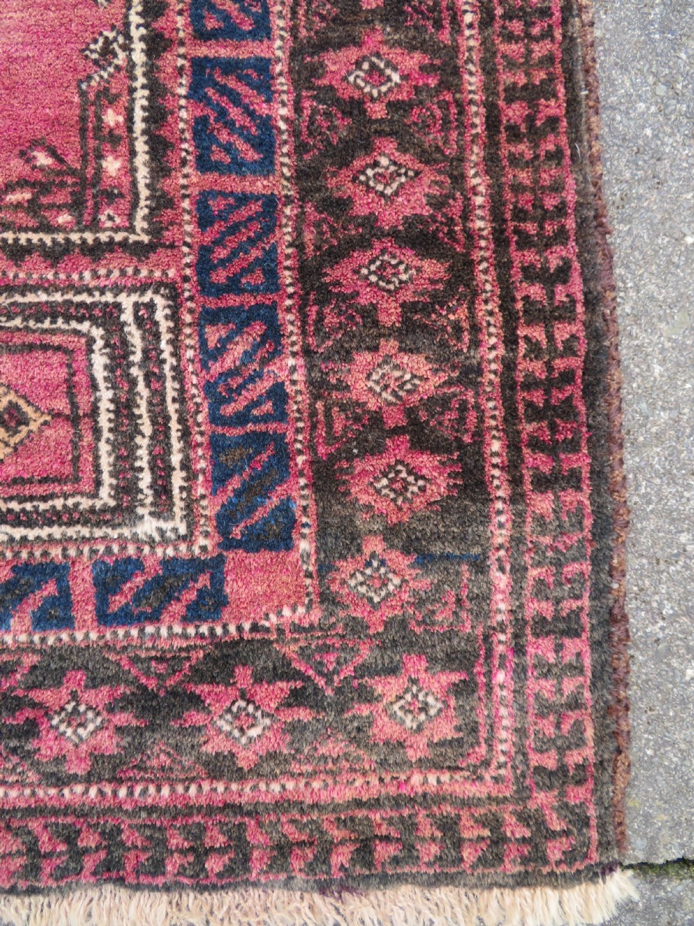 An antique hand-knotted Turkmen Kizil Ayak wool prayer rug featuring a triple mihrab arch design in deep red, dark blue, and charcoal shades. View X