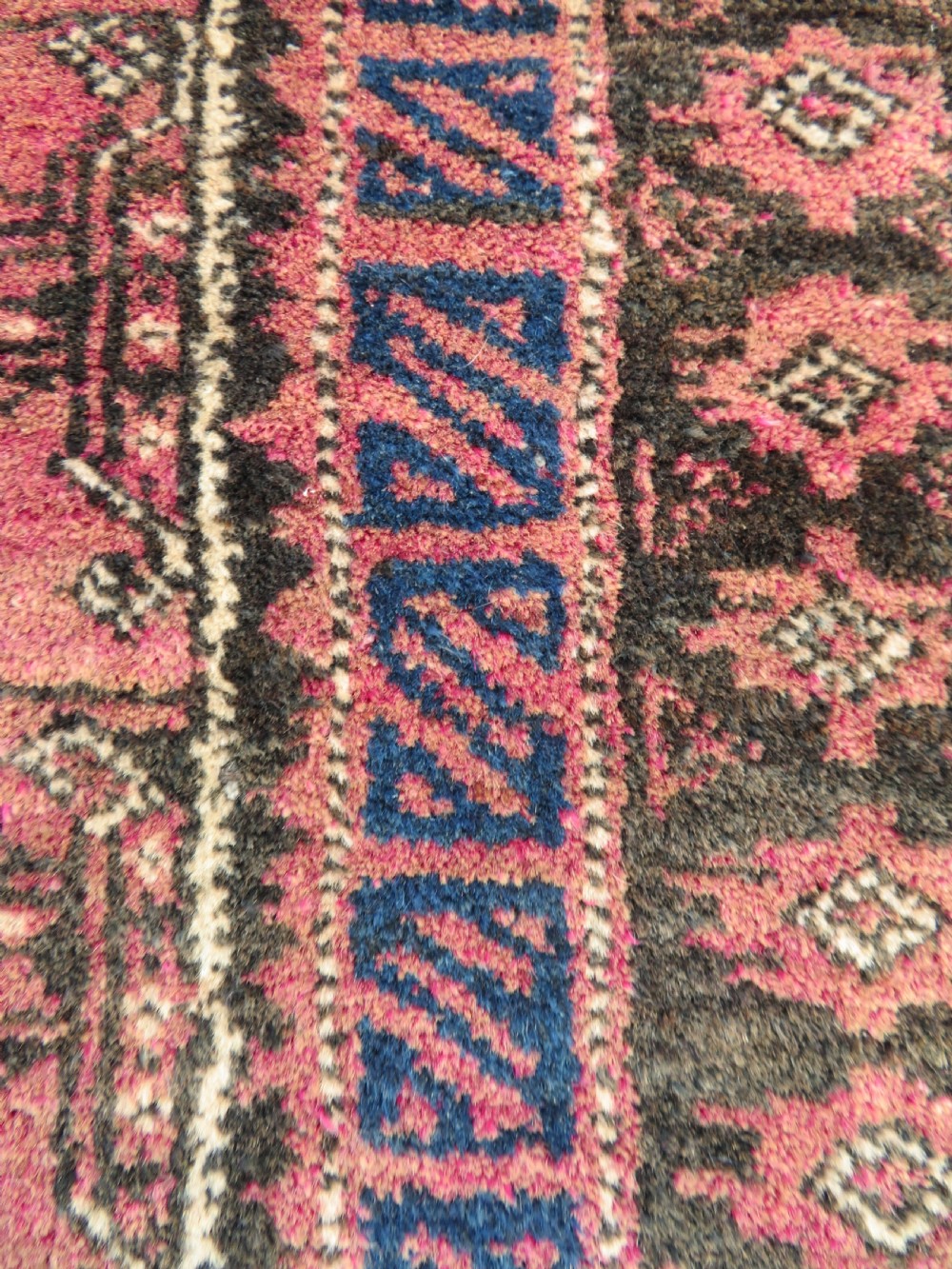 An antique hand-knotted Turkmen Kizil Ayak wool prayer rug featuring a triple mihrab arch design in deep red, dark blue, and charcoal shades. View XI