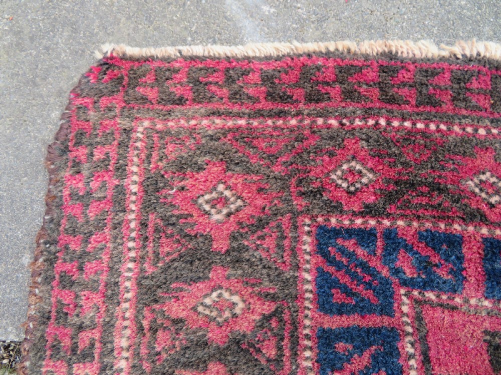 An antique hand-knotted Turkmen Kizil Ayak wool prayer rug featuring a triple mihrab arch design in deep red, dark blue, and charcoal shades. View XIV