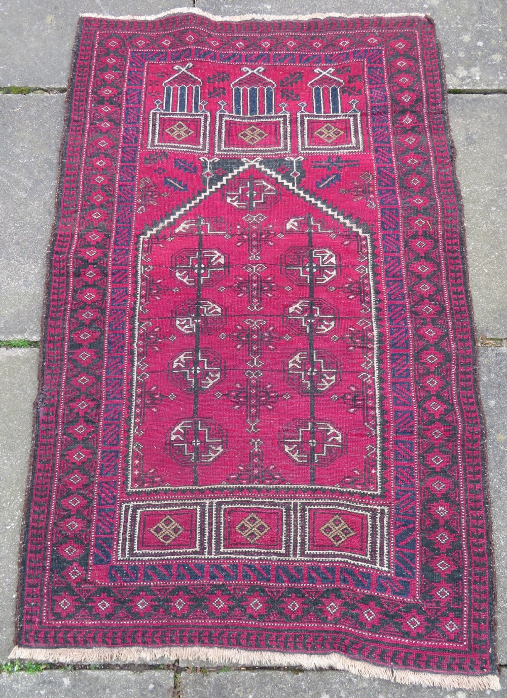 An antique hand-knotted Turkmen Kizil Ayak wool prayer rug featuring a triple mihrab arch design in deep red, dark blue, and charcoal shades. View XVI