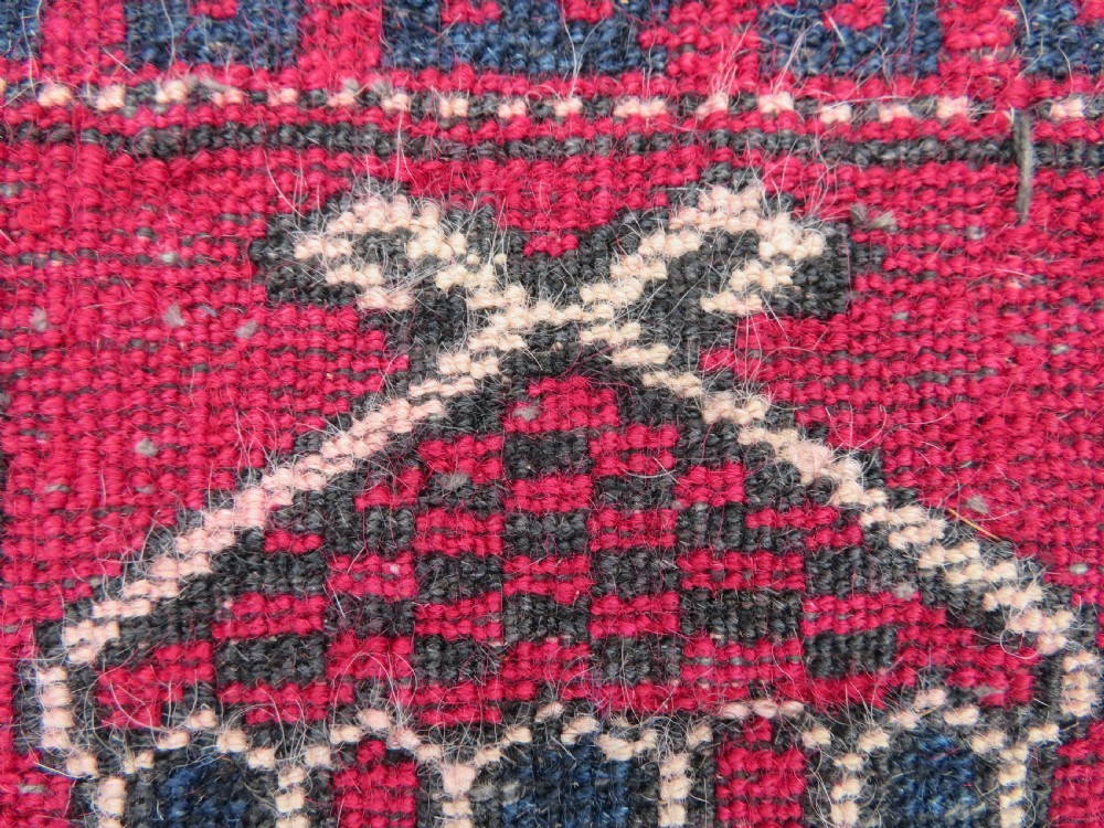 An antique hand-knotted Turkmen Kizil Ayak wool prayer rug featuring a triple mihrab arch design in deep red, dark blue, and charcoal shades. View XVII