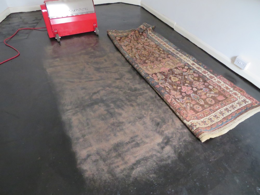 An antique Kurdish wool runner rug featuring a dark brown central field filled with pink and blue geometric motifs surrounded by a cream floral border. View XXVII