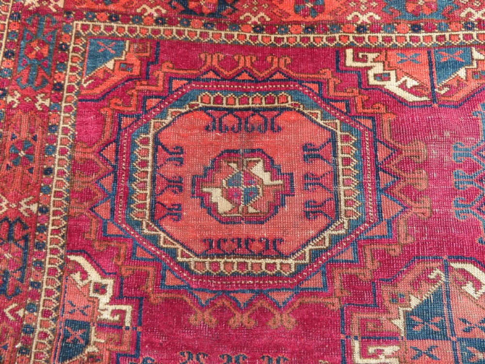 A mid-nineteenth-century hand-knotted Tekke Turkmen wool chuval face featuring six octagonal guls on a deep crimson ground with an intricate bottom elem border. View II
