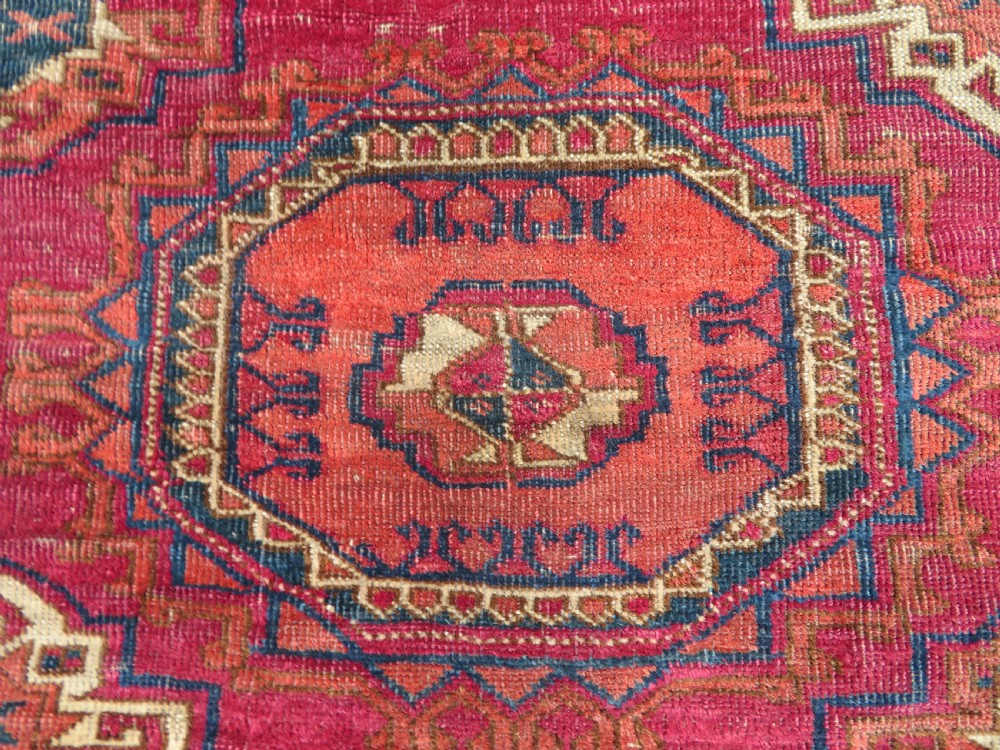 A mid-nineteenth-century hand-knotted Tekke Turkmen wool chuval face featuring six octagonal guls on a deep crimson ground with an intricate bottom elem border. View IV