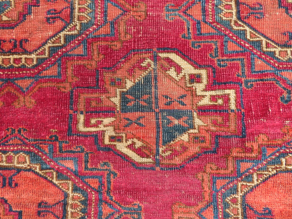 A mid-nineteenth-century hand-knotted Tekke Turkmen wool chuval face featuring six octagonal guls on a deep crimson ground with an intricate bottom elem border. View VI