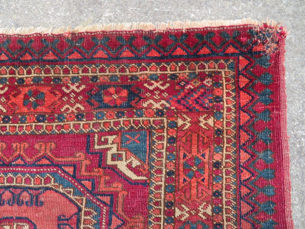 A mid-nineteenth-century hand-knotted Tekke Turkmen wool chuval face featuring six octagonal guls on a deep crimson ground with an intricate bottom elem border. View IX