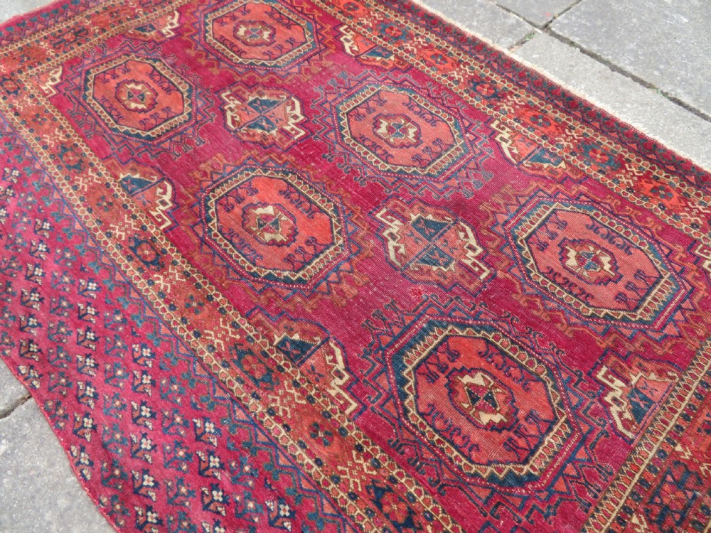 A mid-nineteenth-century hand-knotted Tekke Turkmen wool chuval face featuring six octagonal guls on a deep crimson ground with an intricate bottom elem border. View XII