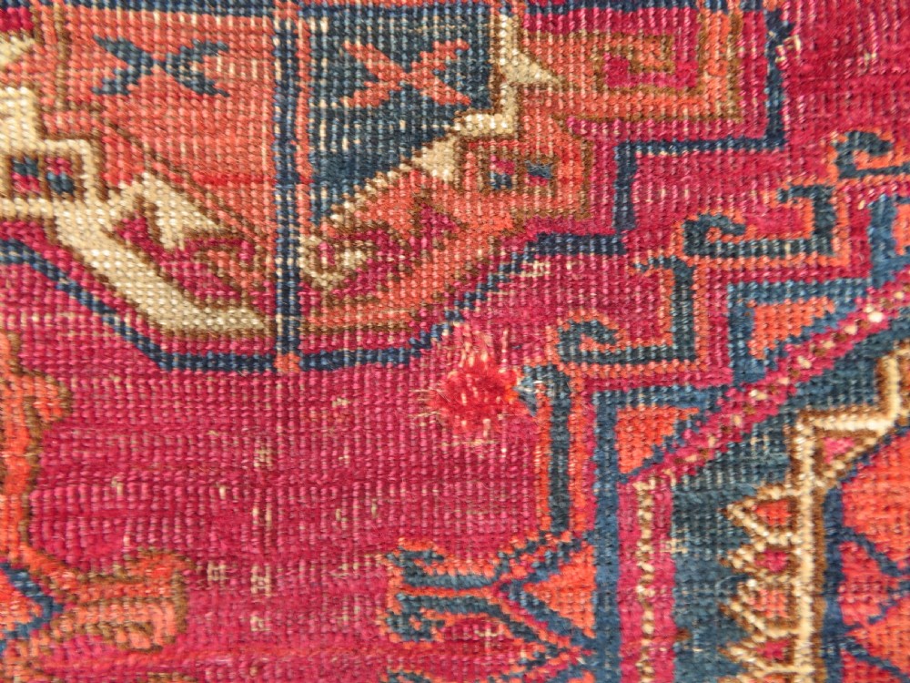 A mid-nineteenth-century hand-knotted Tekke Turkmen wool chuval face featuring six octagonal guls on a deep crimson ground with an intricate bottom elem border. View XIII