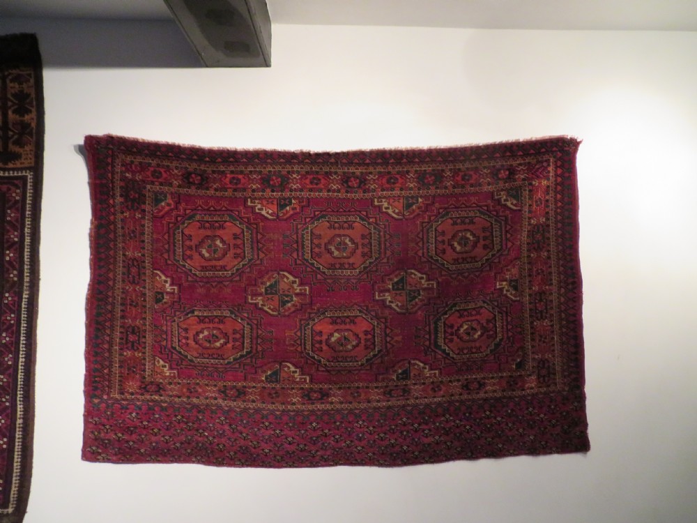 A mid-nineteenth-century hand-knotted Tekke Turkmen wool chuval face featuring six octagonal guls on a deep crimson ground with an intricate bottom elem border. View XX