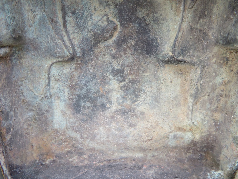 A dark copper alloy sculpture depicting Buddha seated on an ornate throne with legs lowered in the European posture. View XXI