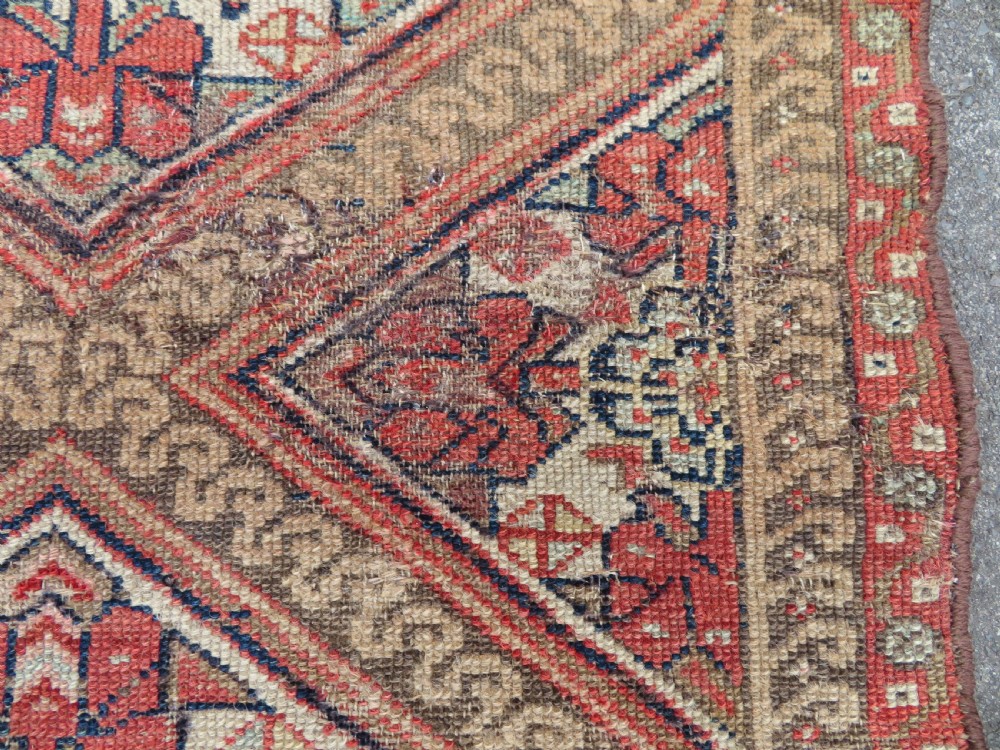 An antique North West Persian Kurdish hand-knotted wool narrow hallway runner featuring repeating diamond medallions in terracotta red, brown, and cream tones. View IX