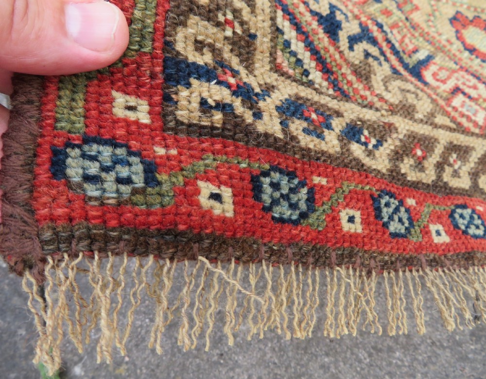 An antique North West Persian Kurdish hand-knotted wool narrow hallway runner featuring repeating diamond medallions in terracotta red, brown, and cream tones. View XII
