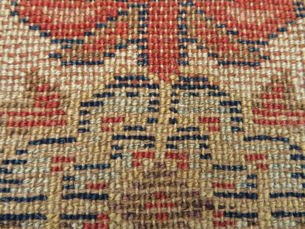 An antique North West Persian Kurdish hand-knotted wool narrow hallway runner featuring repeating diamond medallions in terracotta red, brown, and cream tones. View XVII