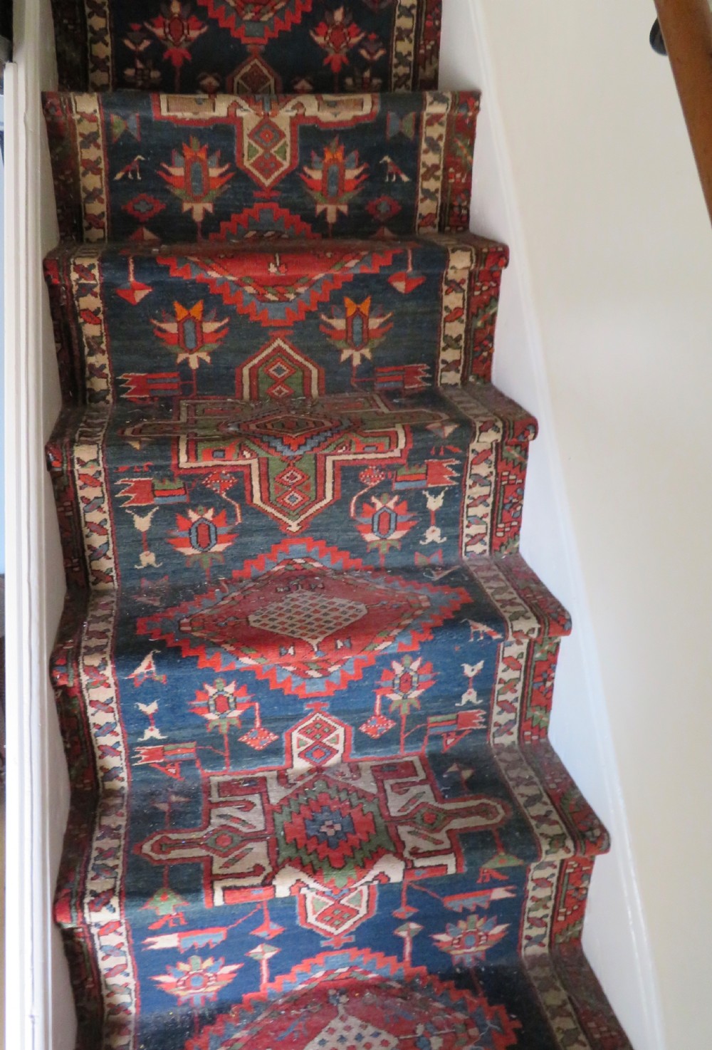 An antique North West Persian Kurdish hand-knotted wool narrow hallway runner featuring repeating diamond medallions in terracotta red, brown, and cream tones. View XIX