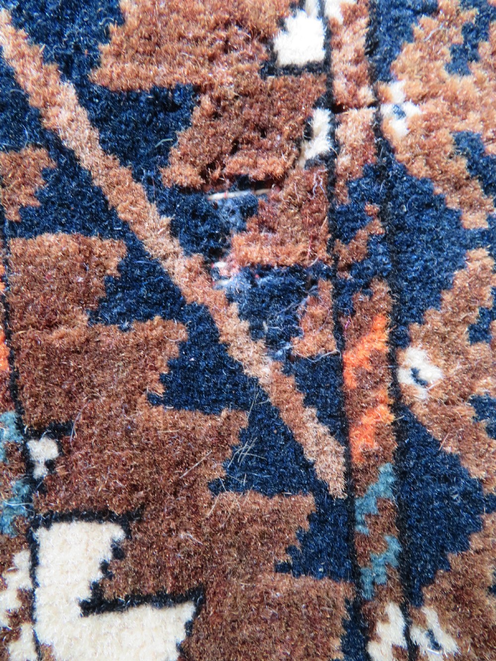 A hand-woven Yomut Turkmen Ok Bash tent-pole bag featuring geometric chevron patterns in rust brown, indigo, and cream wool, finished with braided ties and multi-coloured tassels. View XV