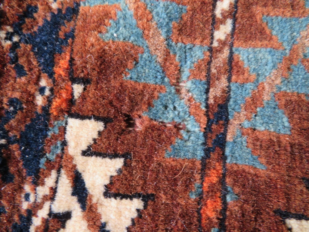 A hand-woven Yomut Turkmen Ok Bash tent-pole bag featuring geometric chevron patterns in rust brown, indigo, and cream wool, finished with braided ties and multi-coloured tassels. View XIX