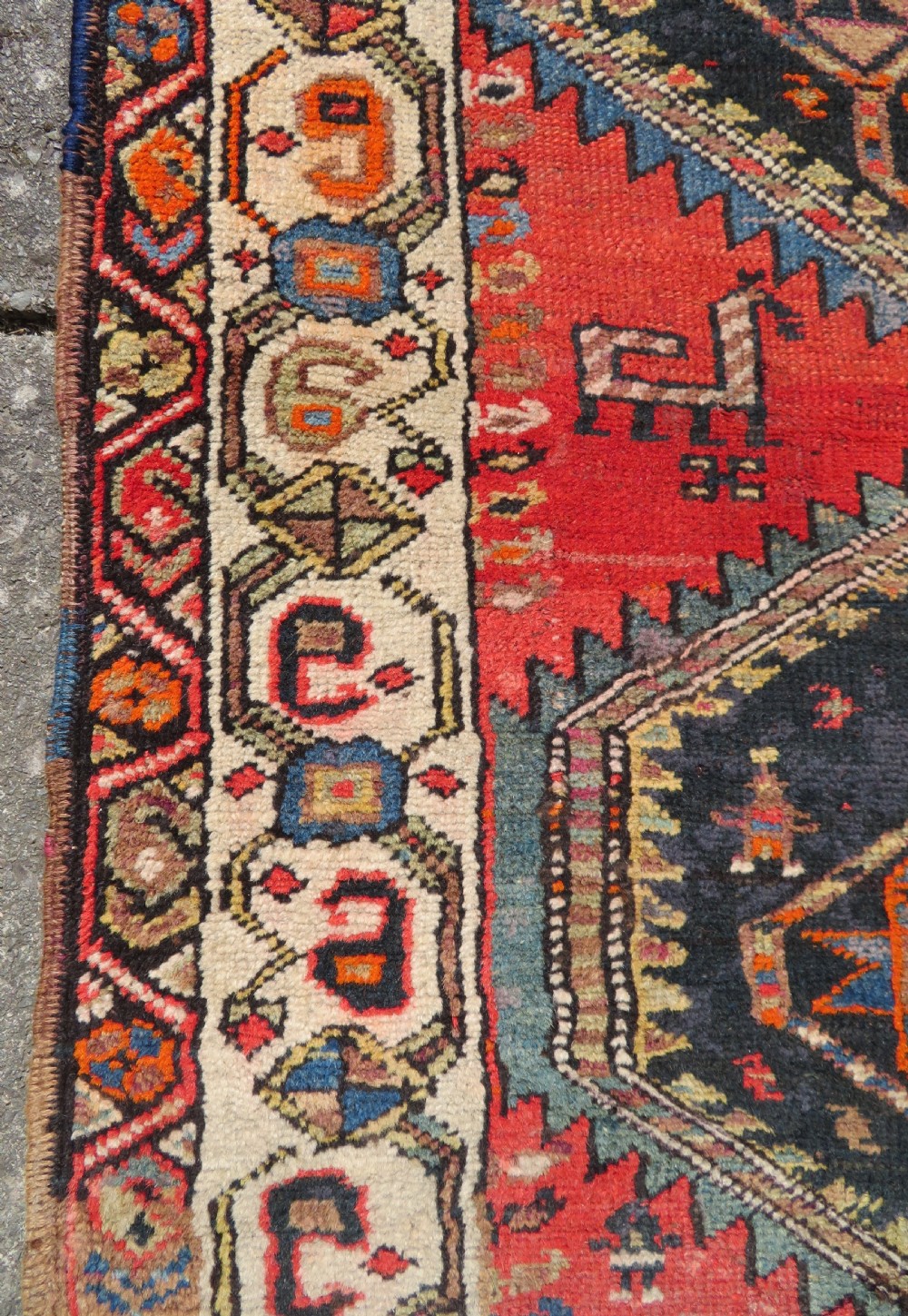 A hand-knotted antique Persian Kurdish wool runner rug with five central diamond medallions on a red field framed by a patterned ivory border. View XVI