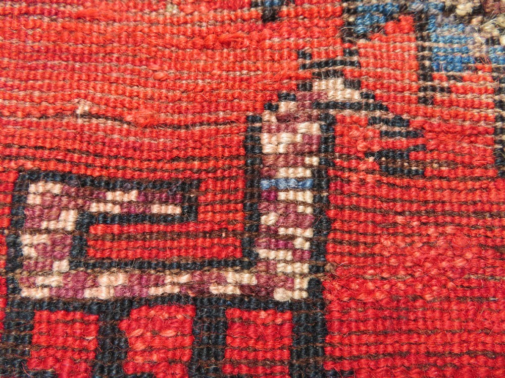 A hand-knotted antique Persian Kurdish wool runner rug with five central diamond medallions on a red field framed by a patterned ivory border. View XXIV