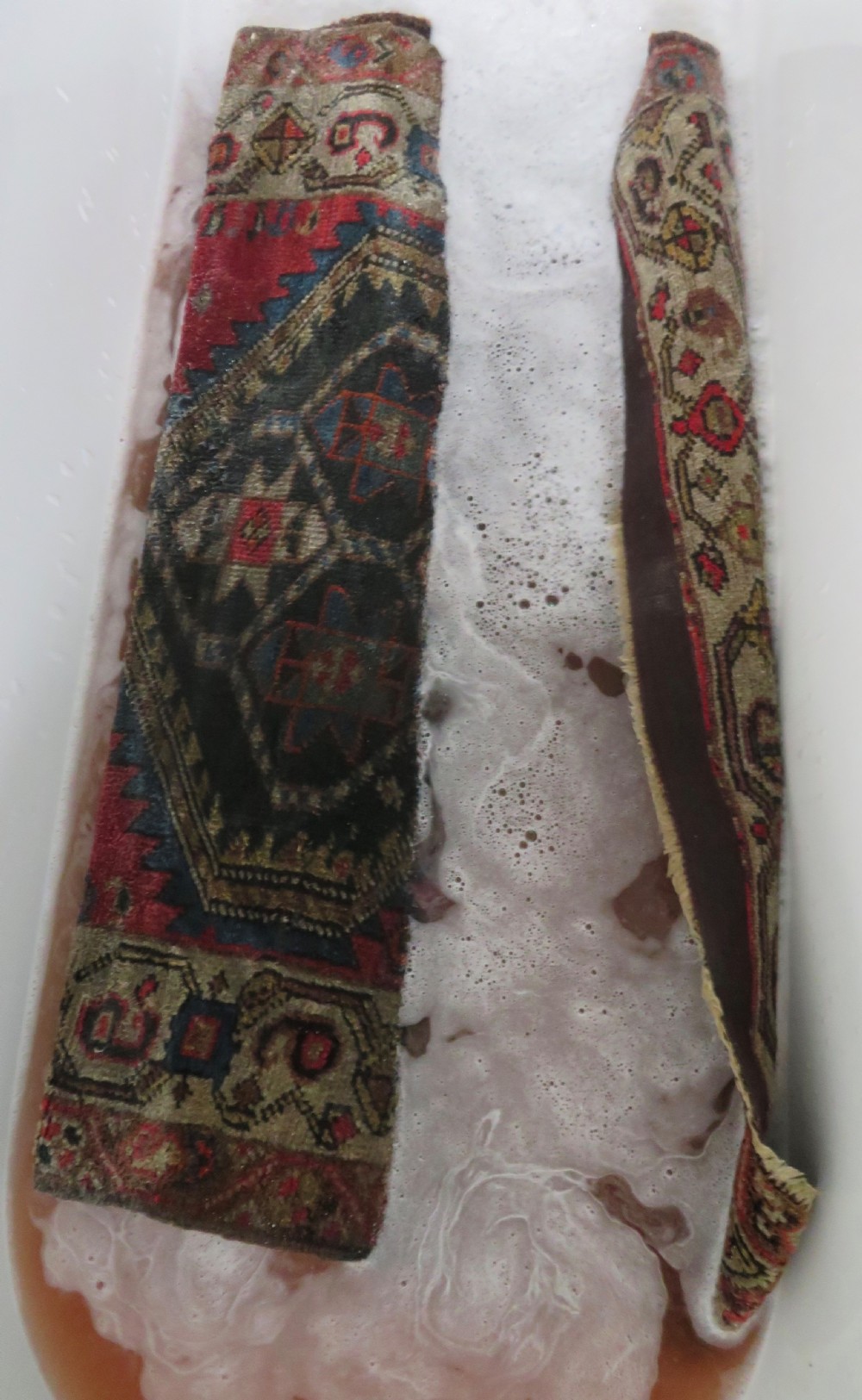 A hand-knotted antique Persian Kurdish wool runner rug with five central diamond medallions on a red field framed by a patterned ivory border. View XXX