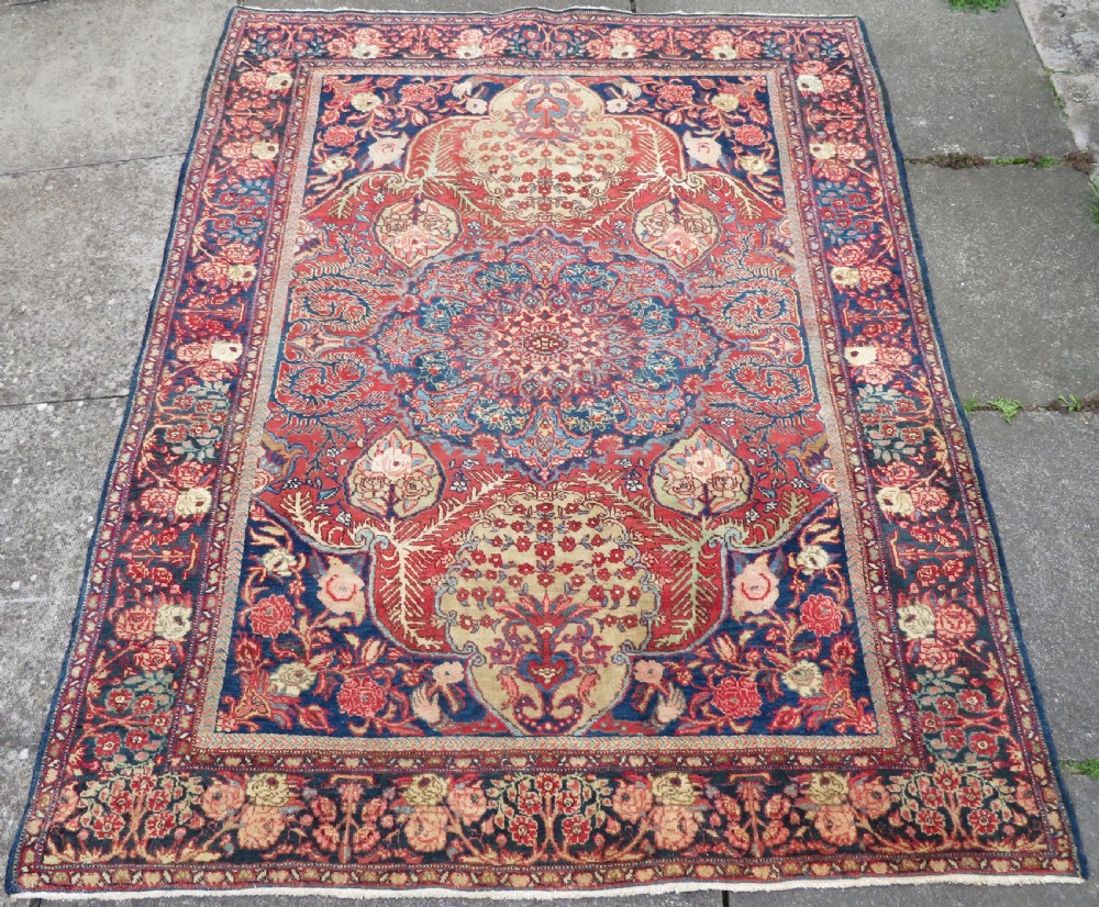 An antique hand-knotted North West Persian Tabriz rug featuring a central floral medallion surrounded by detailed terracotta red, navy blue, and cream motifs. View II