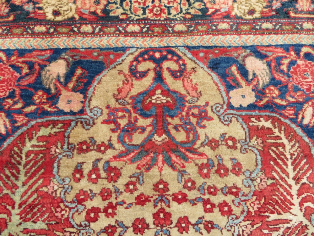 An antique hand-knotted North West Persian Tabriz rug featuring a central floral medallion surrounded by detailed terracotta red, navy blue, and cream motifs. View IX