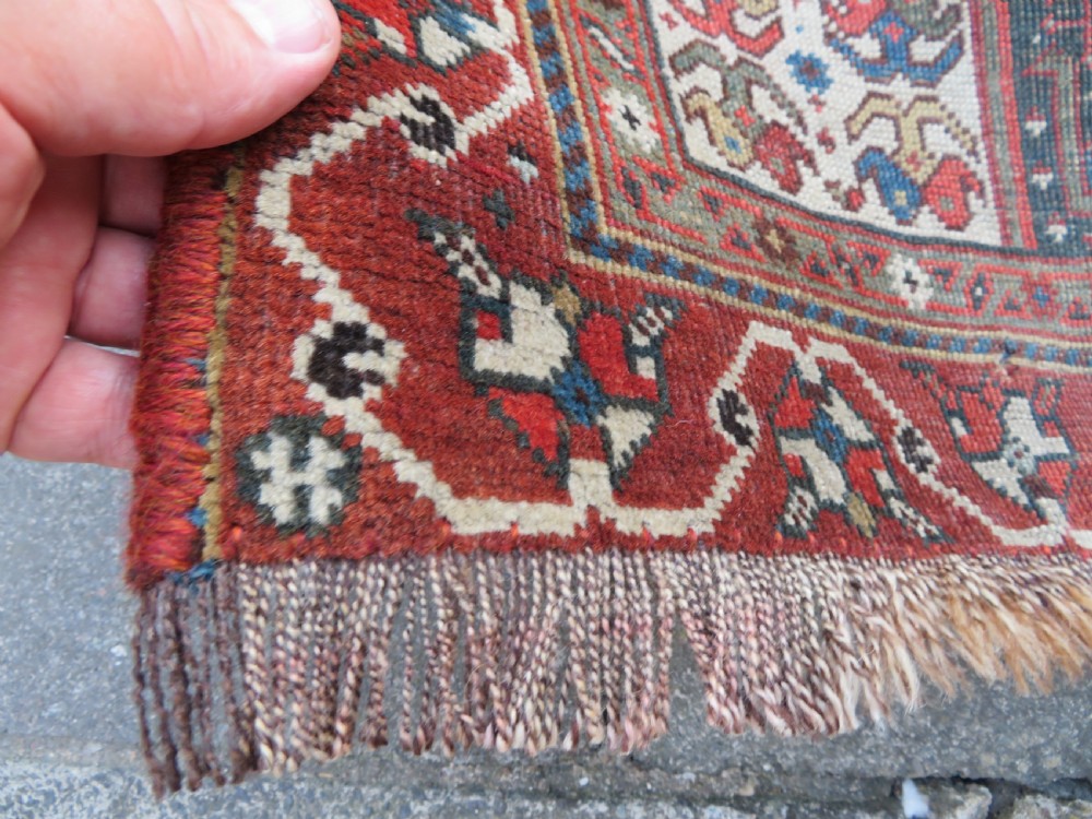 An antique hand-knotted Qashqai wool runner rug featuring repeating geometric diamond medallions in red, blue, and cream tones. View XXI