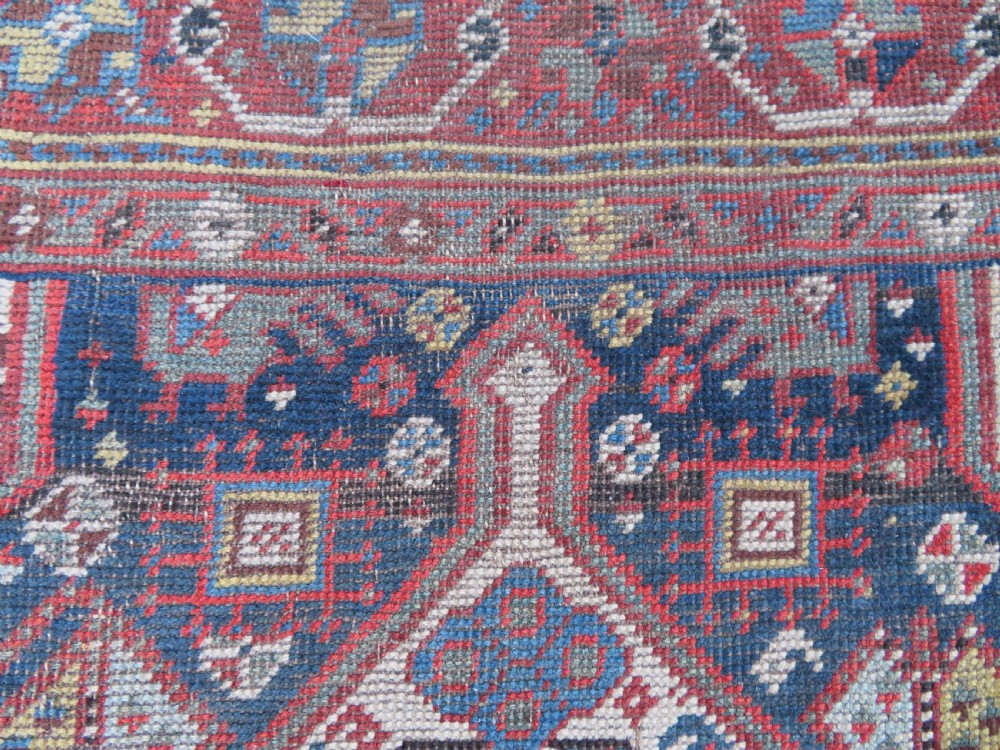 An antique hand-knotted Qashqai wool runner rug featuring repeating geometric diamond medallions in red, blue, and cream tones. View XXIII