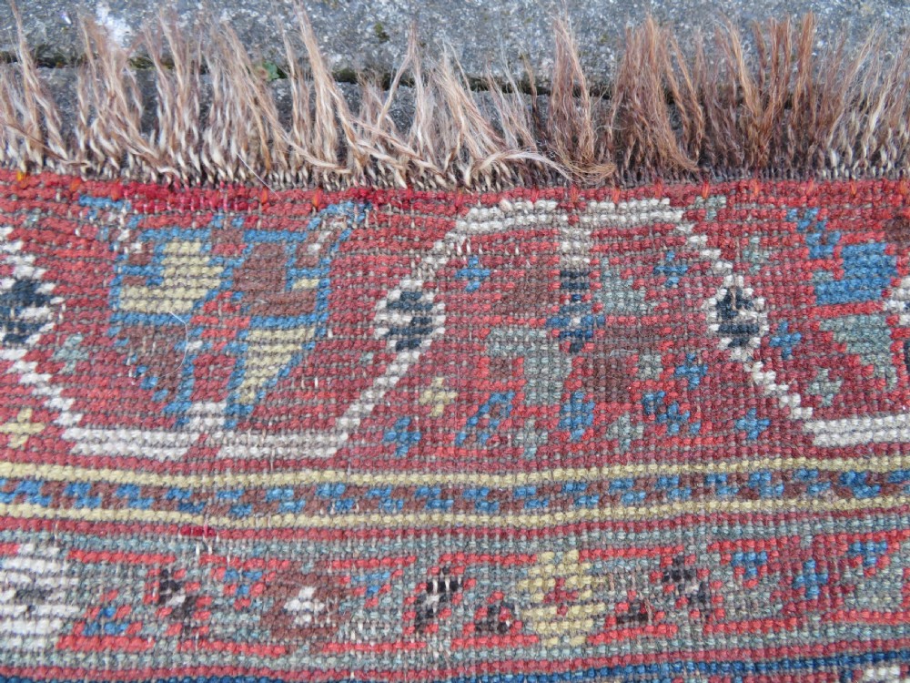 An antique hand-knotted Qashqai wool runner rug featuring repeating geometric diamond medallions in red, blue, and cream tones. View XXIV